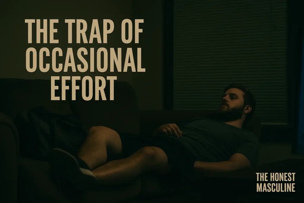 The Trap of Occasional Effort — a man slouched on a couch in workout clothes with his gym bag tossed aside, TV glowing in the background, symbolizing failed consistency.